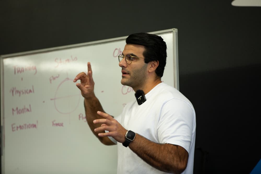 Richard Aceves teaching at the whiteboard during a Moved Academy session